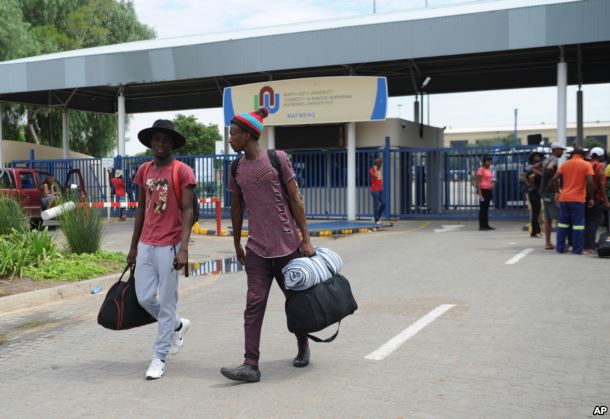 FILE - Students leave the campus at the North-West University in Mahikeng, South Africa, (also known as Mafikeng) Feb. 25, 2016, after protesting students burned down parts of the campus.
